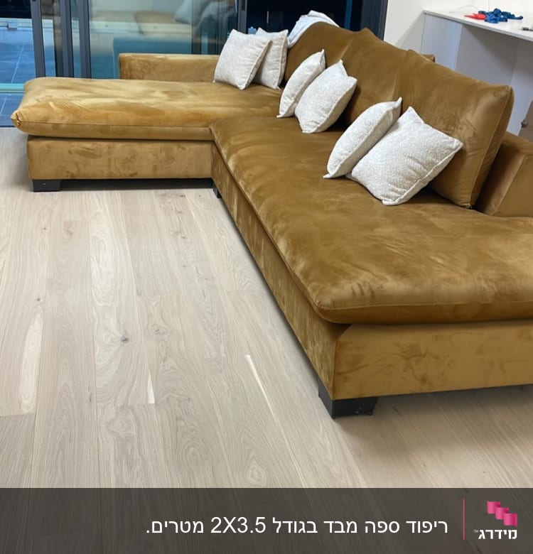 ספה חומה עם כריות לבנות על רצפת עץ בהירה